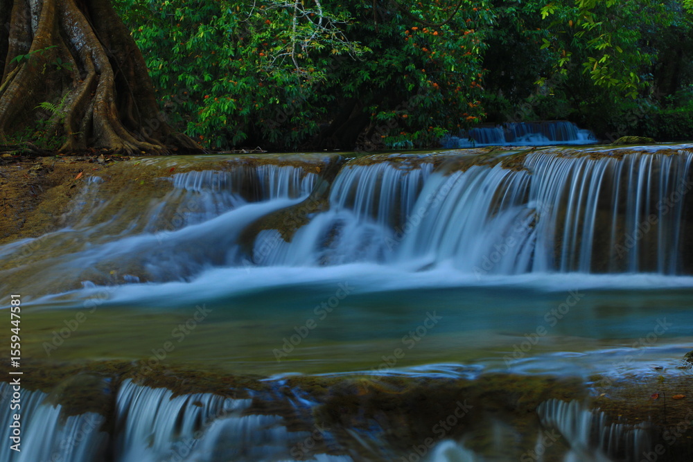 Fototapeta premium Namtok Chet Sao Noi or Chet Sao Noi waterfall, the famous tourist attraction of Saraburi is a 7-tiered waterfall that is clean and shady with various large and small trees. THAILAND