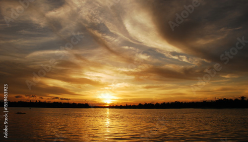 Dramatic sunset over mountain landscape. Beautiful landscape foggy hills twilight time. Blue golden sky sunrise dramatic beautiful landscape mountain. Dawn sky gold dusk time cloudscape with sunlight