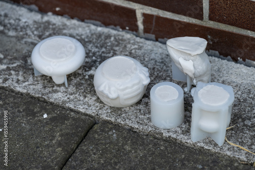 Wallpaper Mural Silicone molds filled with plaster outdoors on concrete near a tiled wall, captured in natural light, showing the contrast between soft casting material and hard surfaces. 
 Torontodigital.ca