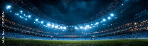 Empty football stadium at night with glowing lights and wide-angle view from ground level, showcasing dramatic sports ambiance and atmospheric lighting.
