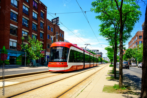 street car making it's way on a dedicated right of way on a summer day in a big city shot in toronto on spadina avenue room for text