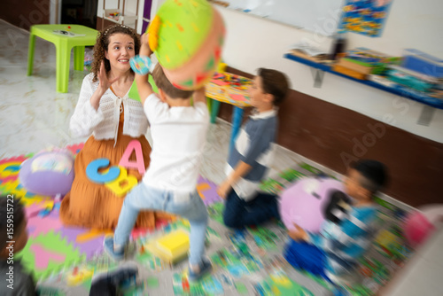 Photos A preschool boy showing challenging behavior while a female teacher calmly interacts with him