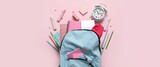 School backpack, alarm clock and stationery on pink background
