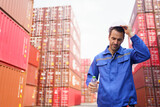 Container yard worker is taking a break and drinking water during a very hot day.
