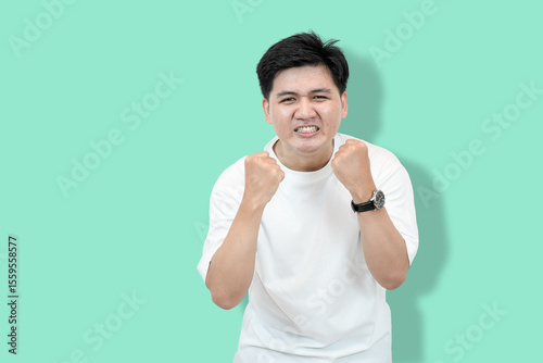 Excited Man Celebrates: Asian Man with Fists Raised in Victory