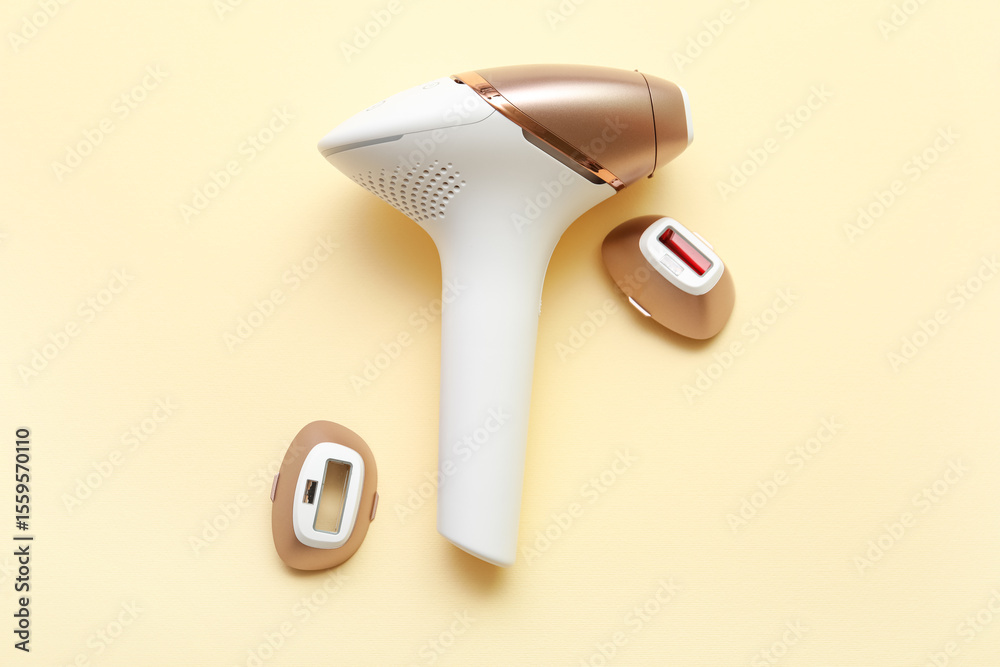 Fototapeta premium Modern photoepilator with attachments on beige background