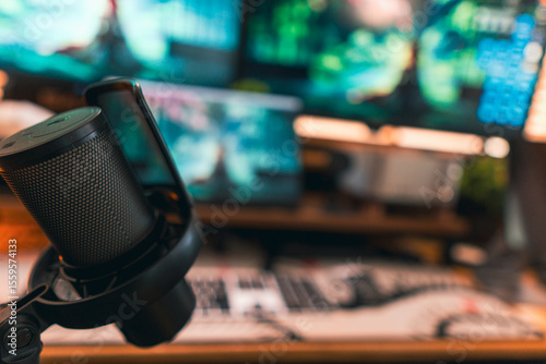 Modern podcast setup with professional microphone on boom arm in cozy home studio, featuring blurred monitors and wooden blinds background. Creative workspace inspiration.