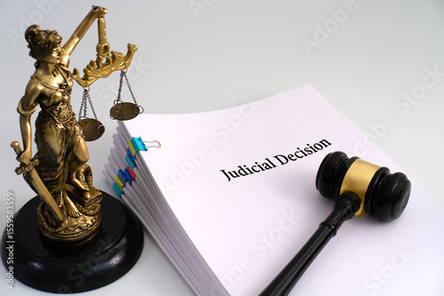 Foto A Lady Justice statue beside a stack of documents titled 'Judicial Decision,' wi
