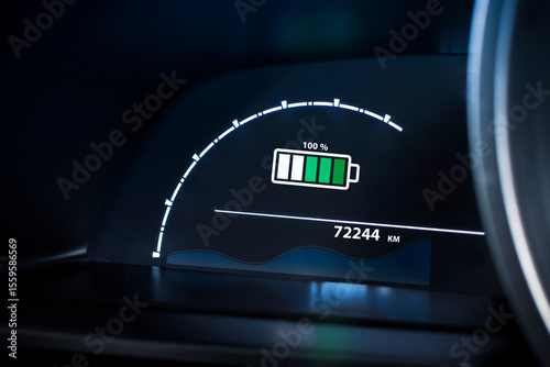 Electric vehicle dashboard showing a 100% battery fully charge. EV, green energy, sustainable transport technology.