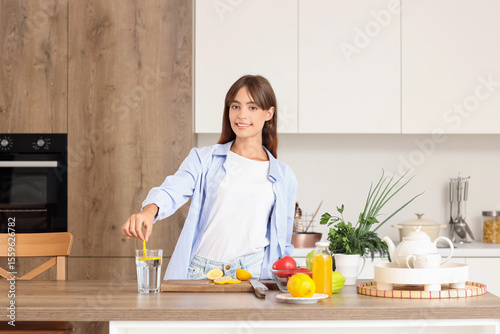 Young woman putting lemon s...