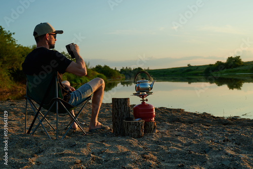 A man is resting on the riverbank