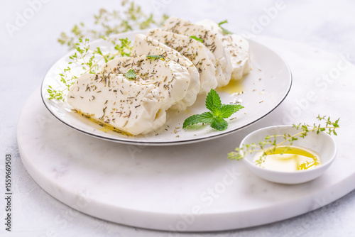 Raw halloumi, Cyprus squeaky cheese with herbs and olive oil prepared for grill