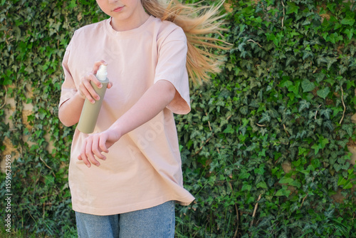 A teenager applies insect spray on his hand. The concept of prevention from mosquito bite.