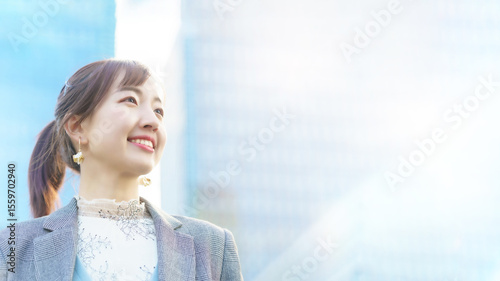 Foto ビル街で空を見上げる若い女性