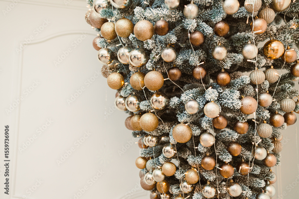 Fototapeta premium A stunning upsidedown Christmas tree that is beautifully adorned with elegant and shimmering gold and silver ornaments, creating a perfect centerpiece for your festive holiday decor and celebrations