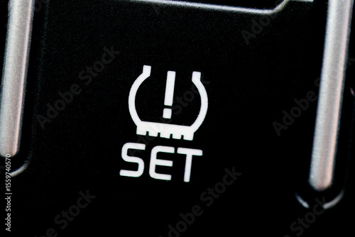 Close-up of the Tire Pressure Monitoring System (TPMS) set button in a vehicle.
