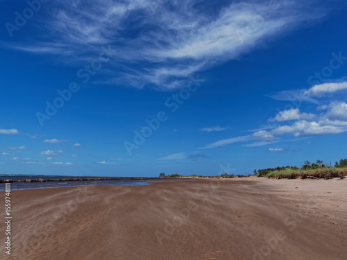 Wind blown sand being swept up the beach at Tentsmuir Point on the south side of the Tay Estuary on a windy day in June.