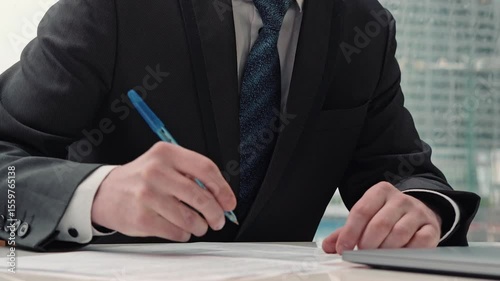 businessman taking notes or signing contract, pen and document, man in formal jacket. close up hand