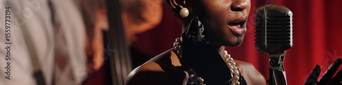 Canvas-taulu African American female vocalist singing into vintage microphone wearing jewelry