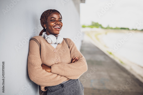 Portrait of young happy black woman with dental braces. She is looking away and smiling.