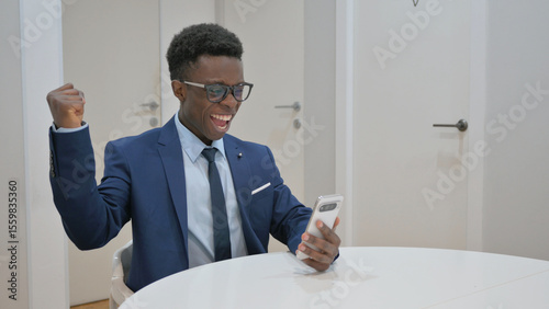 Excited African Businessman Celebrating Success on Phone