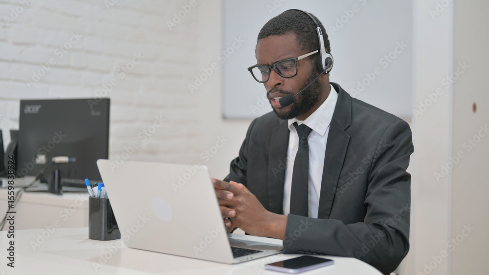 Businessman Actively Speaking with Headset on Laptop Businessman Actively Speaking with Headset on Laptop
