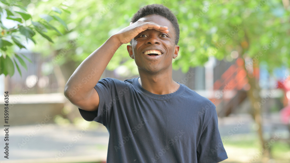 Obraz premium Searching Casual African Man Expressing Overwhelm or Despair Outdoors