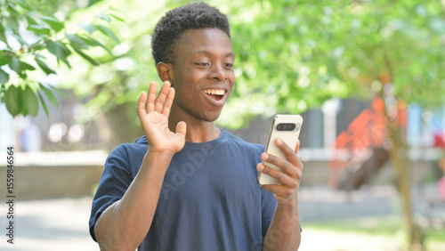 Talking Casual African Man Doing a Video Call Outdoors