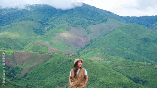 Blurred of a female traveler looking at a greenery mountain views