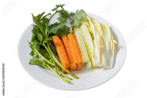 Fresh Vegetable Arrangement on Plate: A colorful array of fresh vegetables, including carrots, cucumber, cabbage, and herbs, artfully arranged on a white plate.