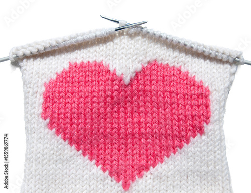 A knitted heart. Knitting a heart with needles. Building releationship concept. A pink hand-made heart in the white background.