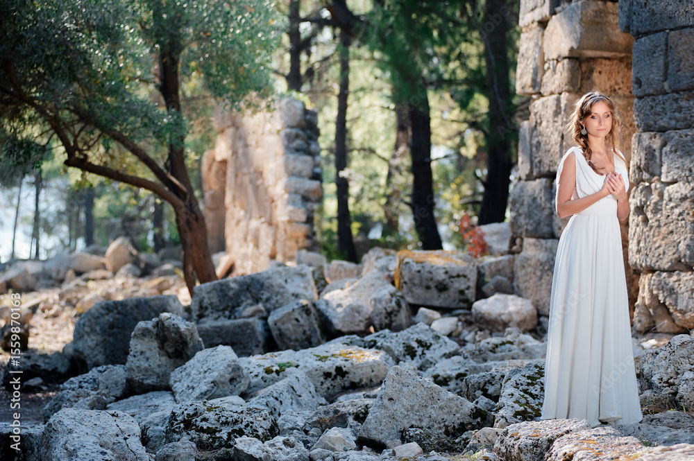 Young beautiful woman wering white dress at antique ruin Young beautiful woman wering white dress at antique ruin