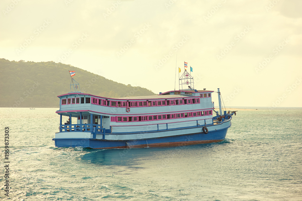 Obraz premium Vibrant coloured ferryboat nagiating through the bay near Samui in Thailand