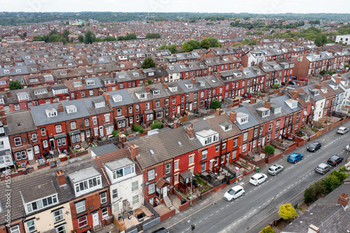 Aerial drone photo of the city of Leeds showing the area know as Harehills with rows of typical British West Yorkshire terrace houses and suburban British neighbourhood with parked cars on the street