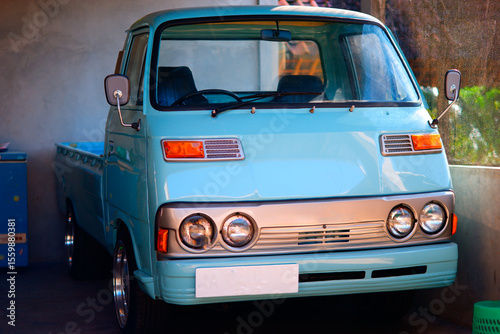 A vintage blue pickuo truck in a garage
