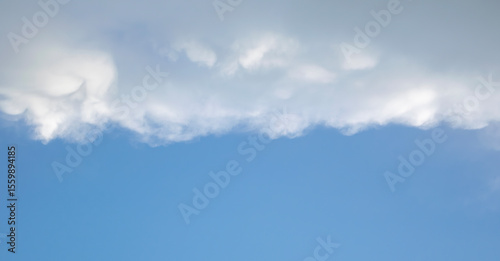 A photo of the sky divided into two parts. One part is cloudy, the other is not.