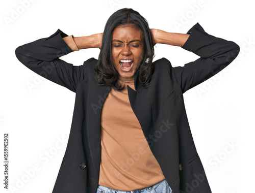 Young Indian woman in business suit covering ears with hands trying not to hear too loud sound.