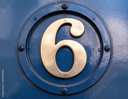 Golden number 6 on blue metallic surface with rivets