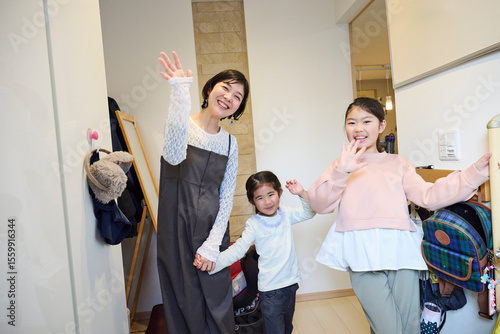 玄関で挨拶する親子の笑顔