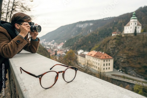 Photographer captures scenic european town with glasses resting on ledge