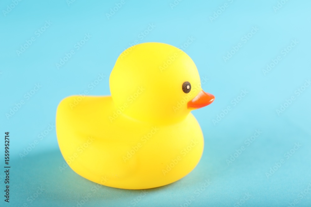 Fototapeta premium One cute rubber duck on light blue background, closeup