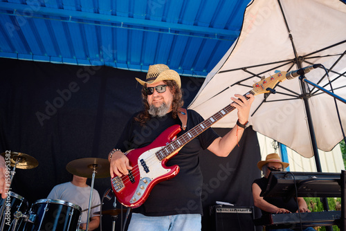 Rock band performing at outdoor venue with upbeat energy and style