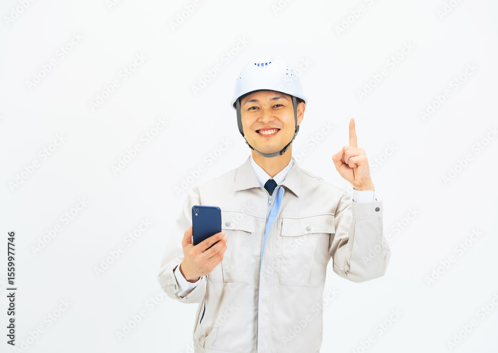 スマホを持っておすすめする作業服を着たミドル男性 スマホを持っておすすめする作業服を着たミドル男性