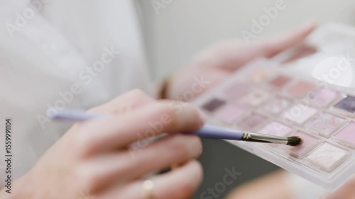 Make-up concept. Makeup artist hand with brush applying makeup. Close-up