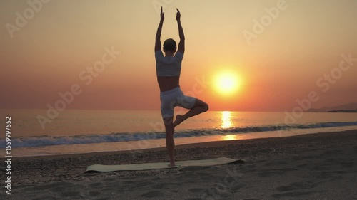 Woman Practicing Tree Pose on Beach at Sunrise