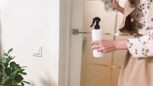 Young woman cleaning home, wiping dust and dirt off doors using eco friendly spray bottle, household cleaning, eco cleaning, dust removal, minimalism, home care 4k video