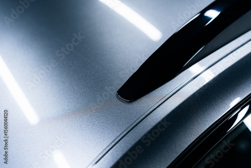 Close-up of car roof with applied PPF film – high-gloss finish, precise edge application and reflection lines on dark metallic paint for automotive protection, detailing and paint preservation visuals