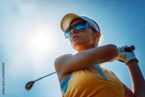 Wallpaper Mural Woman golfer with sunglasses watching her ball fly, dynamic shot, bright midday sun. Torontodigital.ca