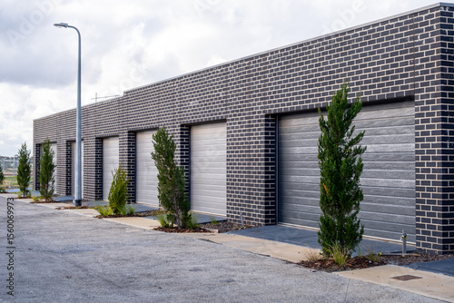 Tableau sur toile Row of contemporary brick garages with roller doors of townhouses in a new suburban housing estate