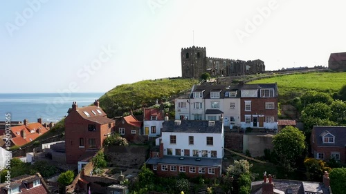 Aerial drone footage of the seaside town of Whitby in East Yorkshire showing the historic British seaside town and St Mary's Church on top of the hill